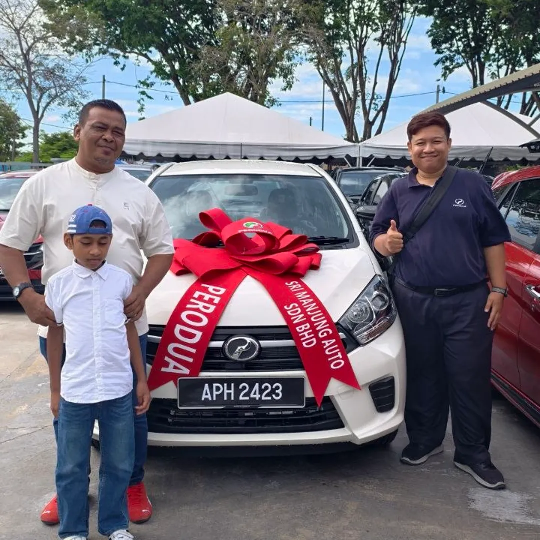 Ayah dan anak menerima Perodua Axia putih baharu