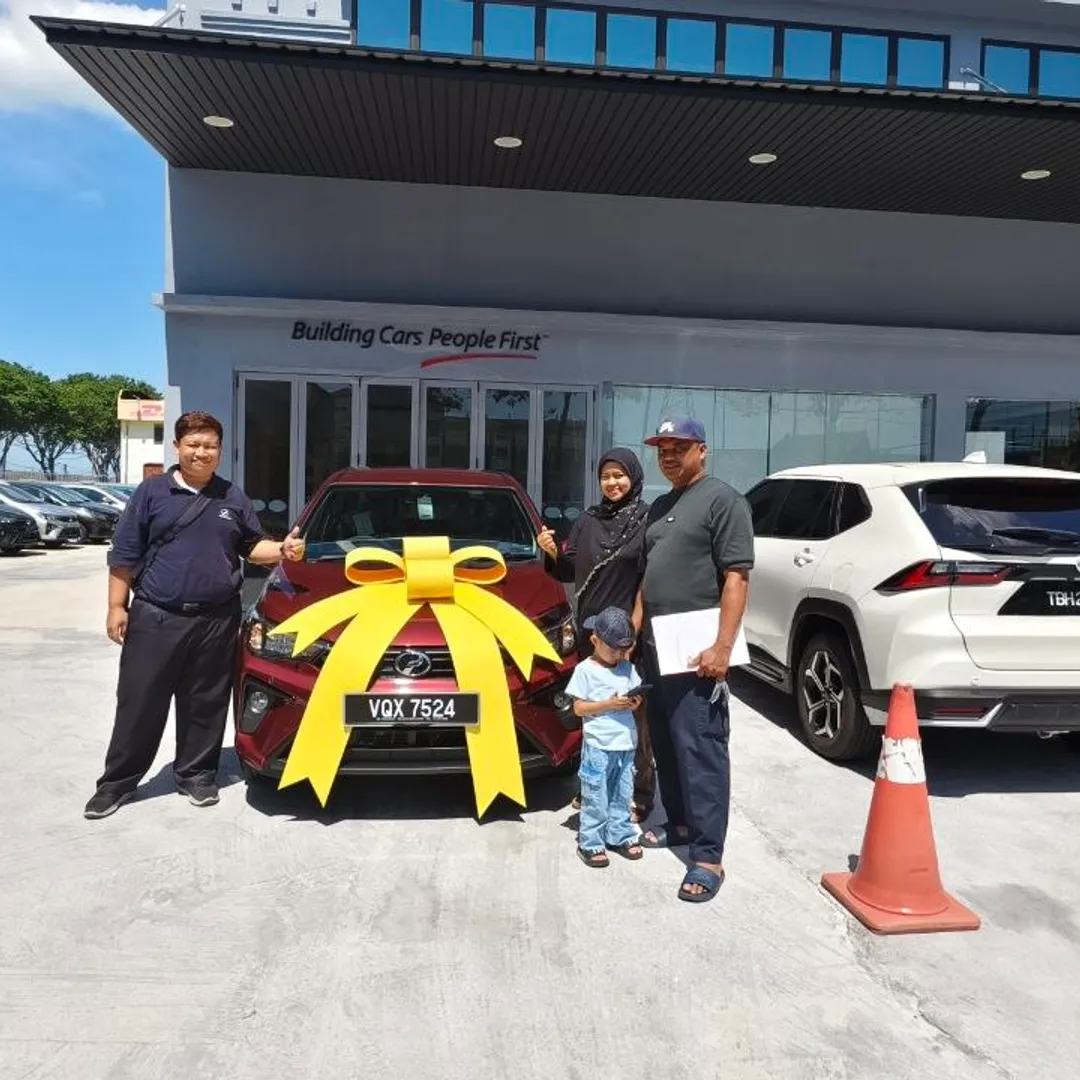 Keluarga menerima kereta Perodua baharu dengan riben kuning