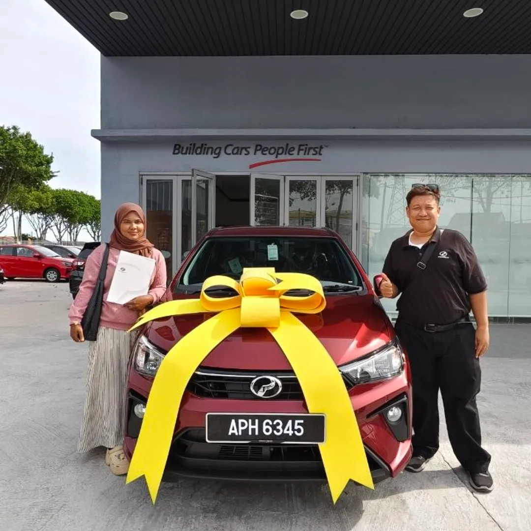 Pelanggan wanita menerima Perodua Bezza baharu di pusat jualan
